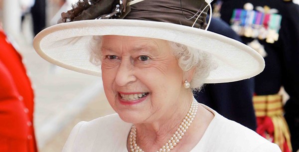 Her Majesty The Queen smiling and walking