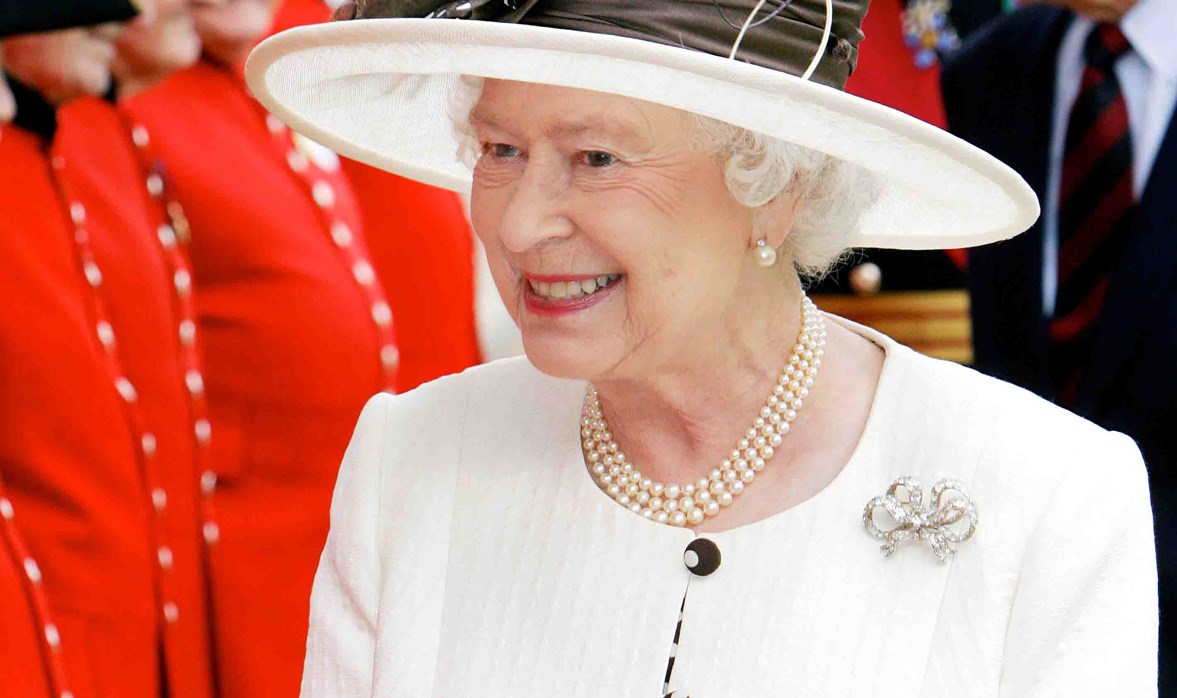 Her Majesty The Queen smiling and walking